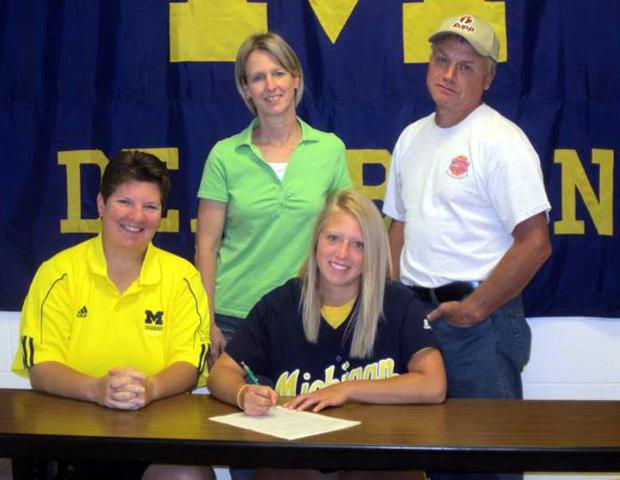 Michelle Hollister, front right, is surrounded by her parents and UM-Dearborn head softball coach Sarah Rotta. Photo by Kristine Dolunt/UM-Dearborn
