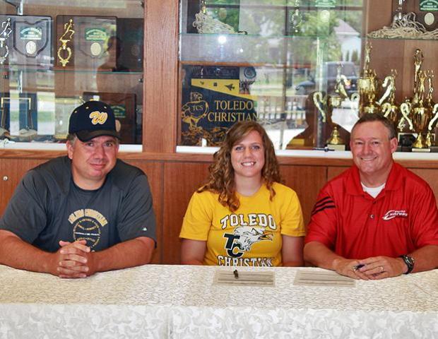Aubrey Geis, center, poses after signing her letter of intent to play for the Express softball program next year. She is joined by her father/Toledo Christian head softball coach Mike Geis and Express softball head coach Duane Lanham. Photo by Nicholas Huenefeld/Owens Sports Information