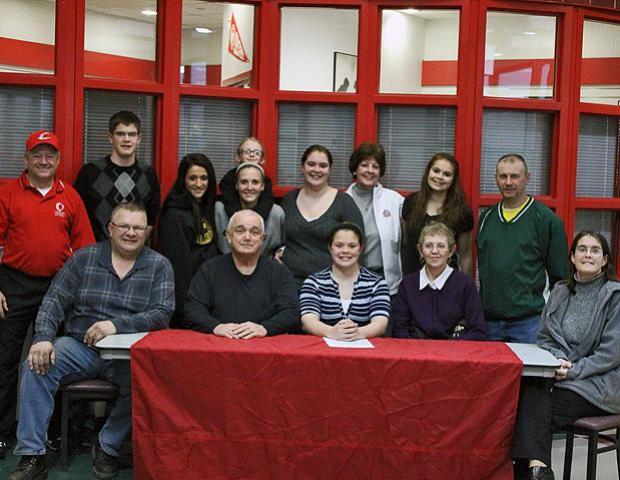 Lesley Ducat, front center, is surrounded by Express softball head coach Duane Lanham (far left), as well as friends and family after signing her letter of intent to play for the Express next year. Photo by Nicholas Huenefeld/Owens Sports Information