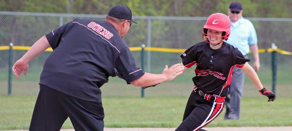 Head coach Marcus Smith greets Emily Young as she rounds third following her third inning grand slam today. Photo by Nicholas Huenefeld/Owens Sports Information