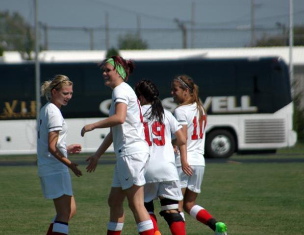 Drew Plummer (green headband) celebrates her goal as Jill Burkholder (far left), Jessica Grindle (19) and Haley Gasser (10) join in. Photo courtesy of Nicholas Huenefeld/Owens Sports Information