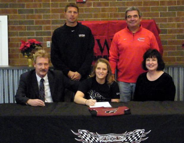Ellie Comes, front center, signs her national letter of intent to play for UNOH. To her right is her father, Robert, and to her left is her mother, Lynn. To her back right is UNOH head volleyball coach Kevin Kitchen and to her back left is Owens head volleyball coach Sonny Lewis. Photo courtesy of Nicholas Huenefeld